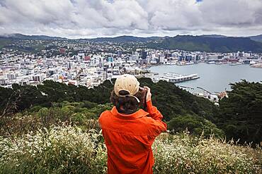 Guy with camera infront of Wellington City, Te Whanganui-a-Tara, Wellington City, Wellington, North Island, New Zealand, Oceania