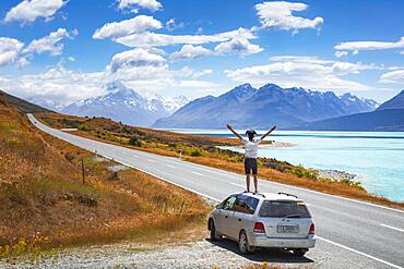 Guy on a car roof, Lake Pukaki, Mount Cook, Canterbury region, Mackenzie District, South Island, New Zealand, Oceania