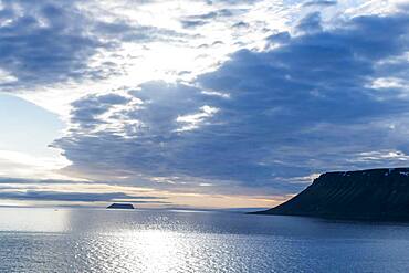 Backlight of flat table mountains covered with ice, Franz Josef Land archipelago, Russia, Europe