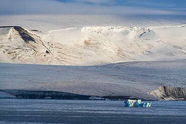 Iceberg floating before the flat table mountains covered with ice, Franz Josef Land archipelago, Russia, Europe