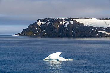 Iceberg floating before the flat table mountains covered with ice, Franz Josef Land archipelago, Russia, Europe