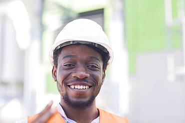 Young black man working outside as technician with helmet and safety vest, Freiburg, Baden-Wuerttemberg, Germany, Europe