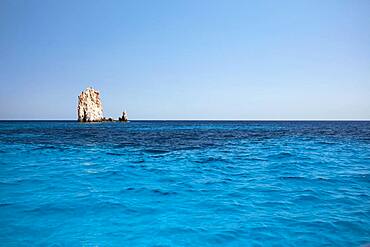 Rock needle in the blue water off the coast of Polyaigos next to Milos, Cyclades, Greece, Europe