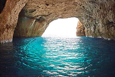 Bright turquoise water at the exit of the collapsed cave Sykia, Milos, Cyclades, Greece, Europe