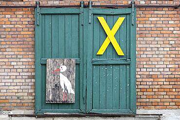 A yellow ""X"", symbol of resistance against nuclear waste transports in the Wendland, on a farm gate in the Rundlingsdorf Kuesten, district of Luechow-Dannenberg, Lower Saxony, Germany, Europe