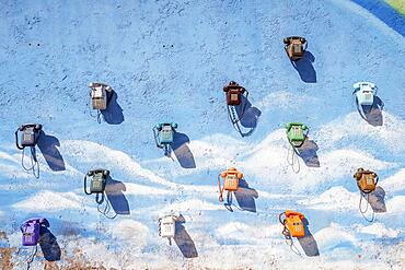 A lot of vintage, colorful telephones hanging on the blue wall in Morocco