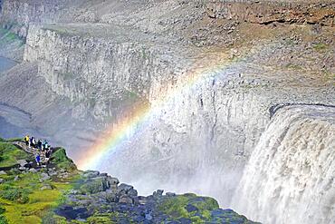 Rainbow in front of waterfall, people on the left, stone desert in the background, Dettifoss, Joekulsa a Fjoellum, Iceland, Europe