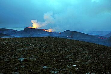 Stone desert and active volcano in the background, Glowing lava fountains, Fagradalsfjall, Reykjanes, Grindavik, Sudurnes, Iceland, Europe