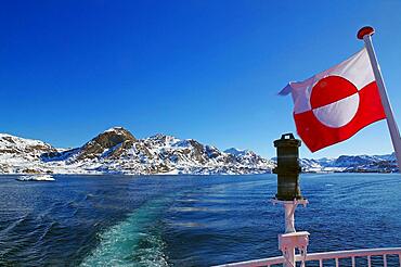 Greenland national flag and coastal landscape with snow, winter, Greenland, Denmark, North America