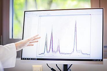 Screen with evaluation diagram and hand pointing to monitor, Freiburg, Baden-Wuerttemberg, Germany, Europe