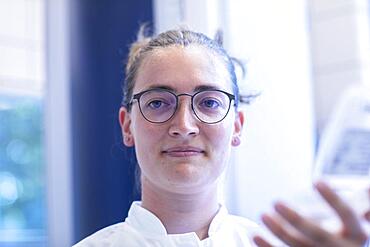 Young laboratory assistant portrait working in a laboratory with laboratory equipment, Freiburg, Baden-Wuerttemberg, Germany, Europe