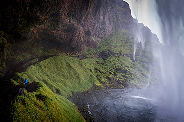 Child behind Seljalandsfoss waterfall, South Iceland, Iceland, Europe