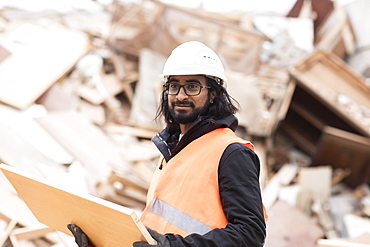 Technician with beard and helmet working in a recycling yard, Freiburg, Baden-Wuerttemberg, Germany, Europe