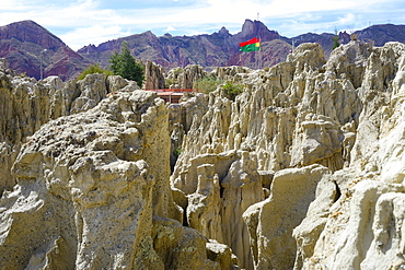 Bizarre rock formations in the Valle de la Luna with flags of la Paz and Bolivia