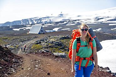 Hiker on the Fimmvoerouhals trail at Baldvinsskali hut, barren volcanic landscape, Porsmoerk Nature Reserve, Suourland, Iceland, Europe