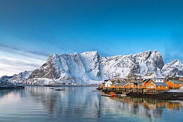 Scandinavian landscape with boathouses at the fjord, sea, mountains, snow, Hamnoy, Nordland, Lofoten, Norway, Europe