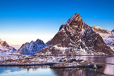 Scandinavian landscape with boathouses at the fjord, sea, mountains, snow, Hamnoy, Nordland, Lofoten, Norway, Europe