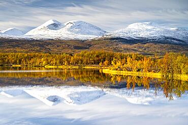 Snowy mountains in Abisko National Park reflected in lake Vuolio Njahkajavri, autumn landscape, Abisko, Lapland, Sweden, Europe