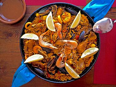 Typical paella pan on wooden table, Spanish rice dish, pan dish, paella pan, pan with Spanish national dish, prawns on paella, mussels in paella, national dish, region of Valencia, Spanish cuisine, Spanish recipes