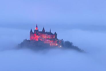 Hohenzollern Castle with Christmas lights above the fog, Hechingen, Baden-Wuerttemberg, Germany, Europe