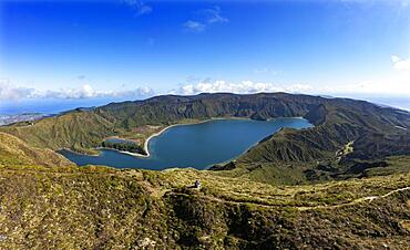 Drone shot, hiker at the summit of Pico da Barrosa with view to the crater lake Lagoa do Fogo, Sao Miguel Island, Azores, Portugal, Europe