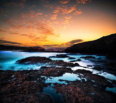 Sunrise, over the sea in a rocky bay, clouds, long exposure, backlight shot, volcanic rock, Fuerteventura, Canary Islands, Spain, Europe