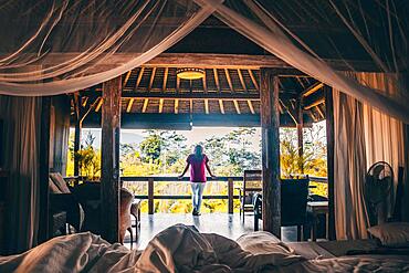 View from a four-poster bed into the morning atmosphere, wooden hotel bungalow in the rice paddies of Sidemen, Bali, Indonesia, Asia