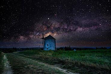 The Old Windmill of Tes iin the night with Milky Way and starry sky. Windmill made of stone and wooden wings in Tez, Transdanubia, Balaton, Hungary, Europe