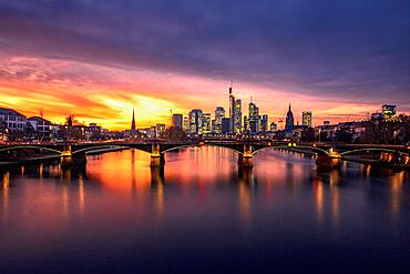 Illuminated skyline with Commerzbank, Hessische Landesbank, Cathedral, Opera Tower, Deutsche Bank, in front the Old Bridge, behind the purple sunset Frankfurt, Hesse, Germany, Europe