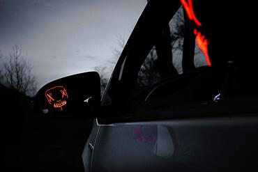 Man with Purge mask in car, reflection in exterior mirror, Frankfurt am Main, Hesse, Germany, Europe