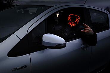 Man with Purge mask in car, giving sign with fingers, Frankfurt am Main, Hesse, Germany, Europe