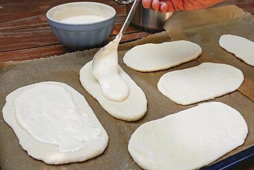 Swabian cuisine, preparation Hohenloher Blootz, Blooz, salty yeast pastry, sour cream, spoon, man's hand, Germany, Europe