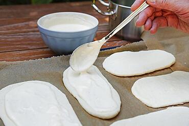 Swabian cuisine, preparation Hohenloher Blootz, Blooz, salty yeast pastry, sour cream, spoon, man's hand, Germany, Europe