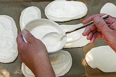 Swabian cuisine, preparation Hohenloher Blootz, Booz, salty yeast pastry, sour cream, spoon, men's hands, Germany, Europe