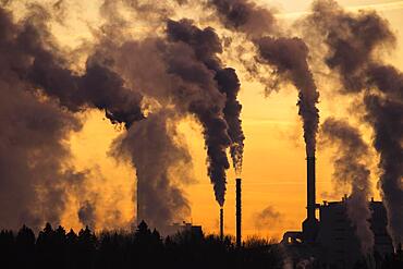 Smoking industrial chimneys in the evening light, Vaermland, Sweden, Europe