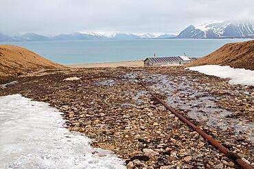 Former mining station Calypsobyen, old pipeline with wooden barrack, view of Bellsund, Spitsbergen Island, Norway, Europe