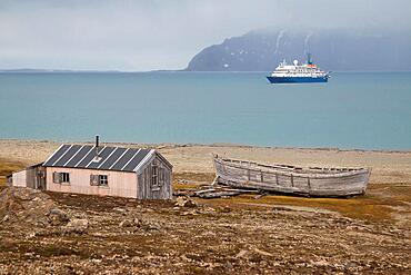 Former mining station Calypsobyen, wooden barrack with wooden boat, view of Bellsund, Spitsbergen Island, Norway, Europe