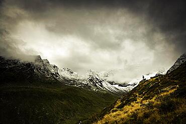 Mountaineers in front of dramatic clouds in mountain landscape, Sellrain, Innsbruck, Tyrol, Austria, Europe