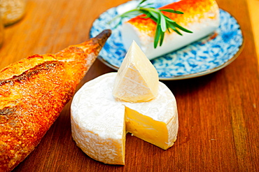 French cheese and fresh baguette on a wood cutter