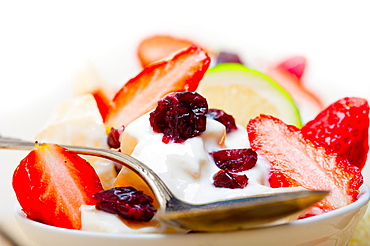 Fruit and yogurt salad healthy breakfast over white wood table