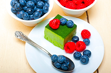 Green tea matcha mousse cake with raspberries and blueberries on top