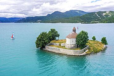 Drone shot, drone photo of the chapel Saint Michel de Pruniers in the lake Lac de Serre Poncon with view of the surrounding mountains, Departement Hautes-Alpes, France, Europe