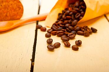 Espresso coffee beans on a paper cone cornucopia over white background