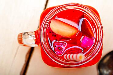 Fresh fruit punch refreshing summer drink over white rustic wood table