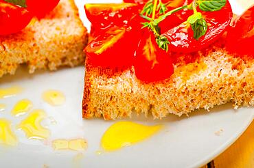 Italian tomato bruschetta with thyme and mint leaves