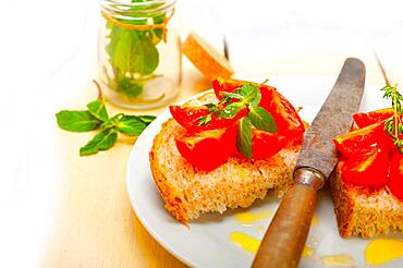 Italian tomato bruschetta with thyme and mint leaves