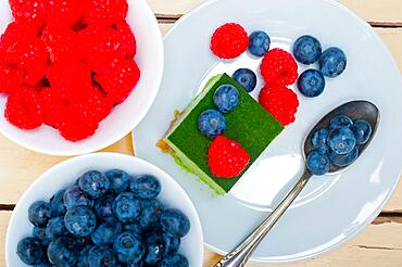 Green tea matcha mousse cake with raspberries and blueberries on top