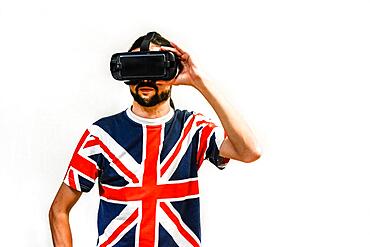 Man on white background with Virtual Reality headsets on, testing new VR technology. Man with 4K Glasses watching games or videos