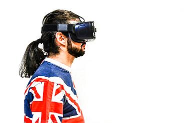 Man on white background with Virtual Reality headsets on, testing new VR technology. Man with 4K Glasses watching games or videos