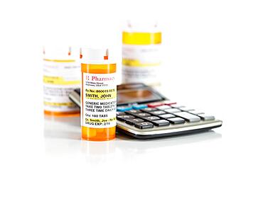 Calculator and non-proprietary medicine prescription bottles isolated on a white background